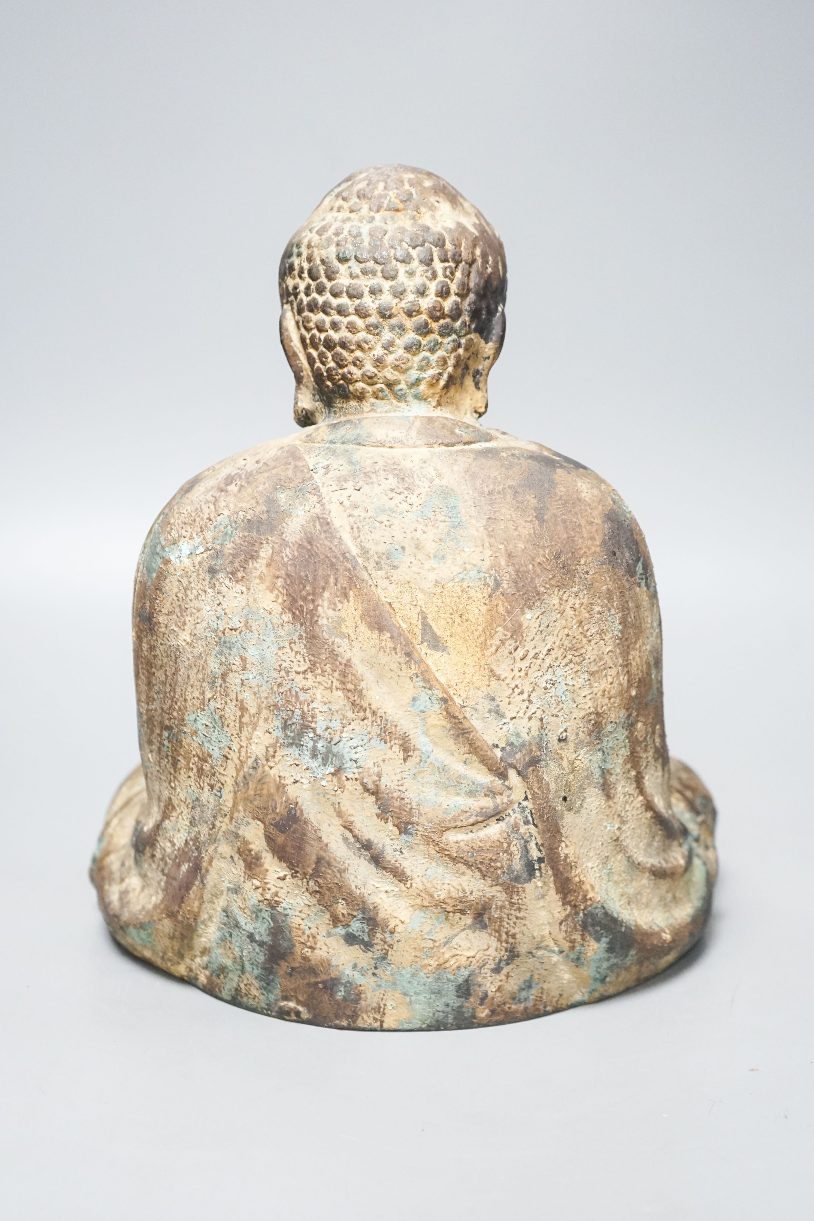 A South East Asian cast iron figure of a seated Buddha 28cm